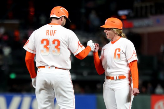 SAN FRANCISCO, CALIFORNIA -  APRIL 12: San Francisco Giants' Darin Ruf (33) fits pumps first base coach Alyssa Nakken after he walked in the fourth inning of a MLB game at Oracle Park in San Francisco, Calif., on Tuesday, April 12, 2022. It is Nakken's first on field appearance by a woman in MLB history. (Ray Chavez/Bay Area News Group)
