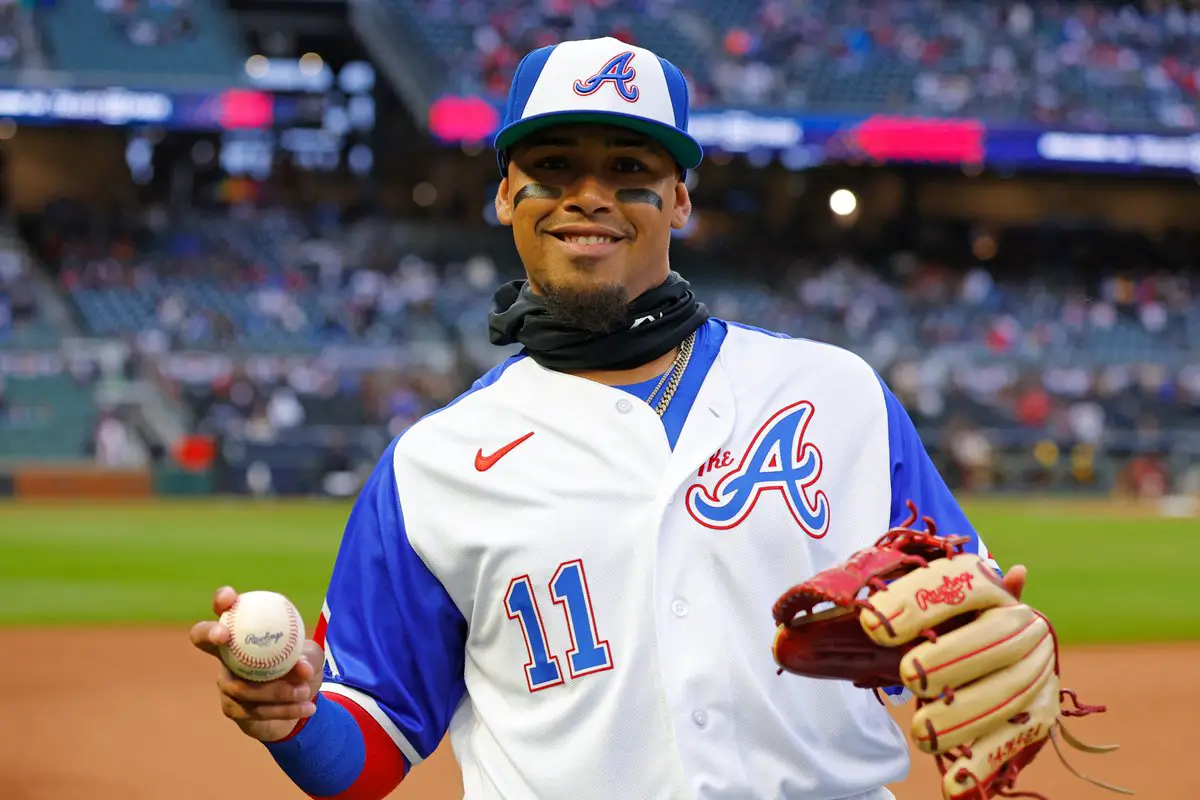 Pictured: Orlando Arcia wearing a white and blue Braves City Connect jersey.  The jersey features a "For the A" logo on the upper left of the jersey with blue sleeves. He has a City Connect blue and white cap featuring the Braves "A" logo on the front.  